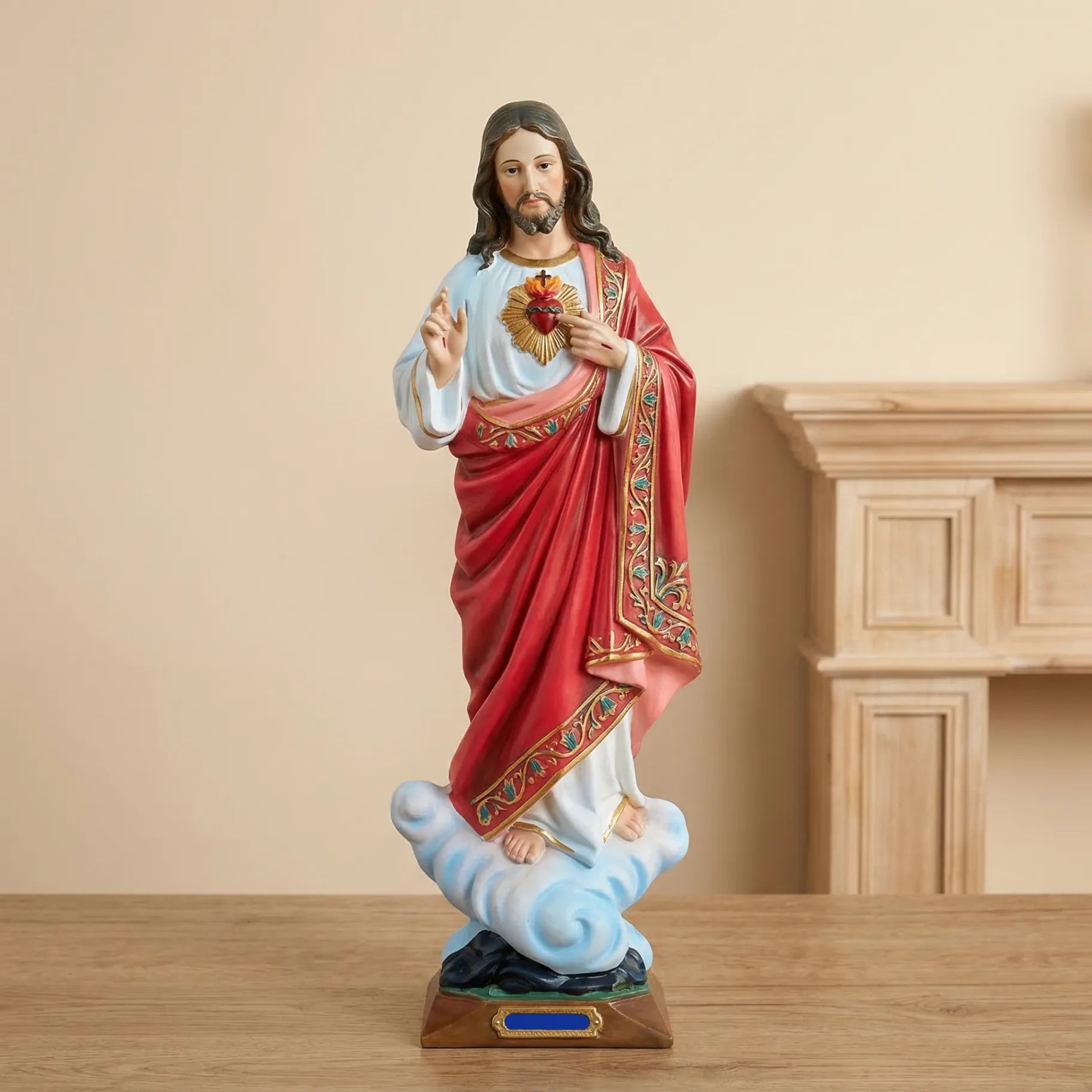 Sacred Heart of Jesus statue with red mantle on a wooden surface