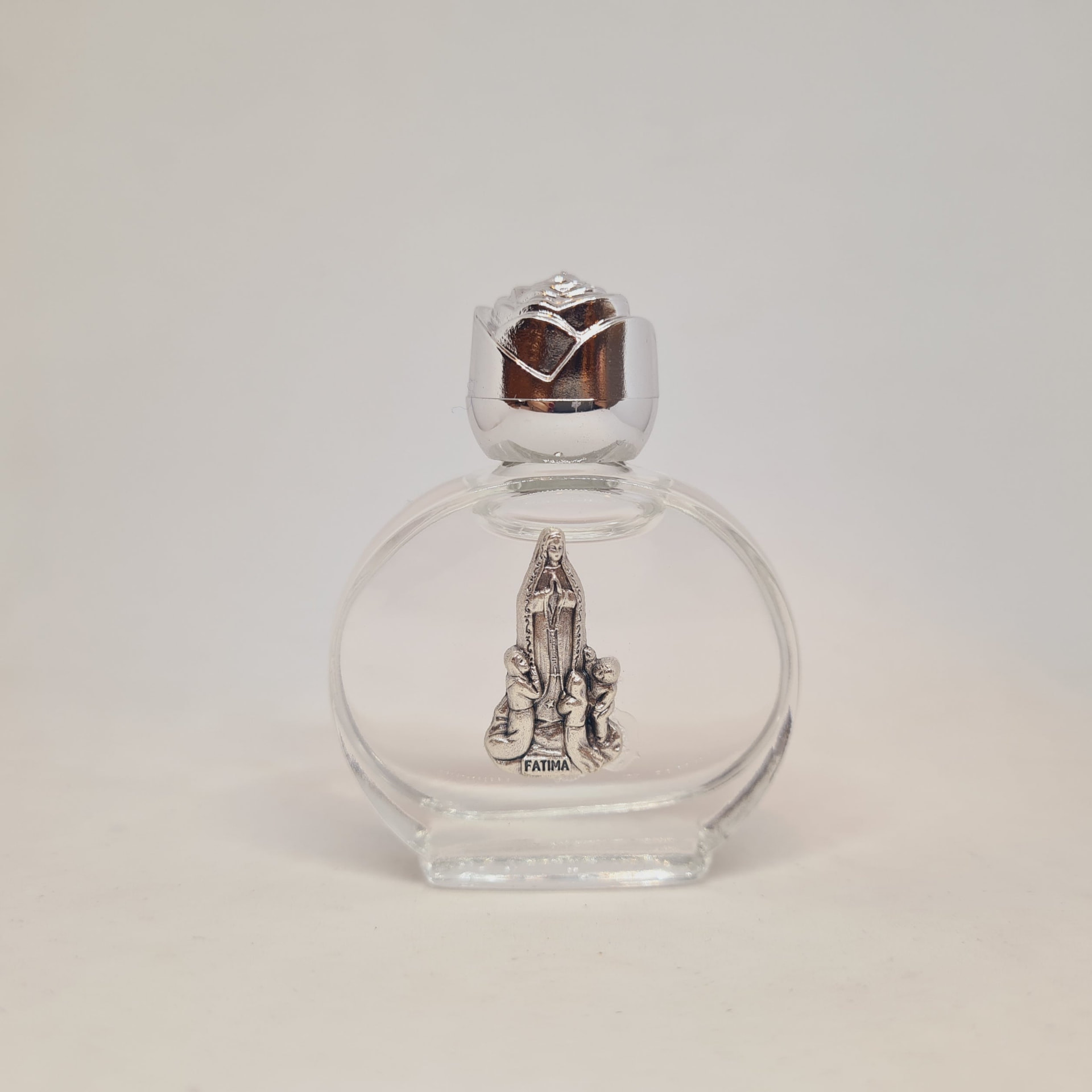 Round glass Fátima holy water bottle with a silver rose cap and apparition figure